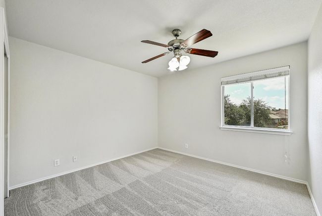 Carpeted empty room with a ceiling fan and baseboards | Image 16
