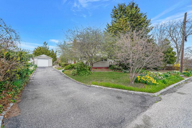 View of front of home featuring driveway, a detached garage, an outdoor structure, and a front yard | Image 10
