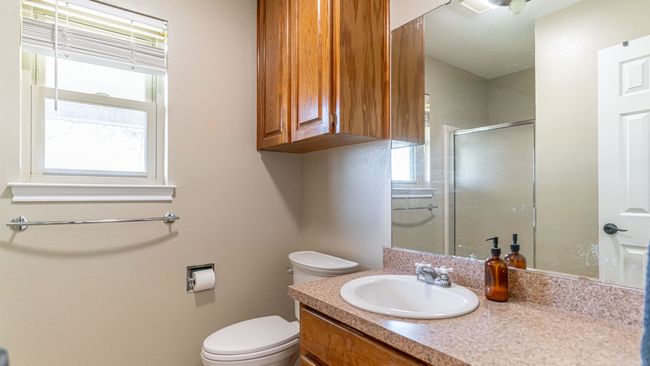 Bathroom with toilet, a shower stall, and vanity | Image 25