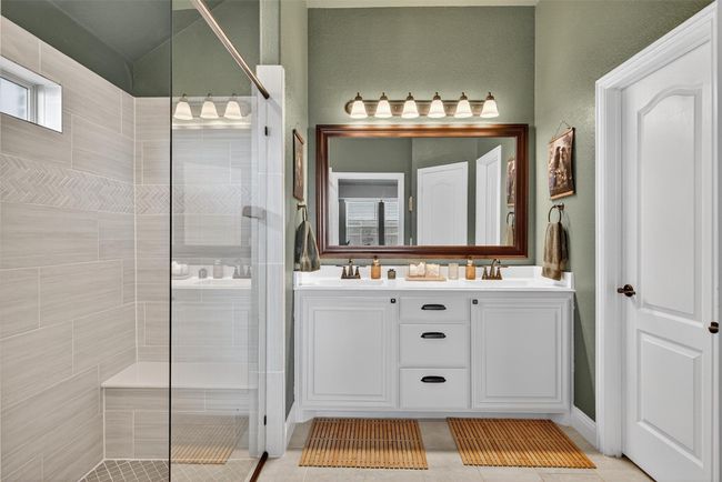 Bathroom with tiled shower, double vanity, and tile patterned floors | Image 26
