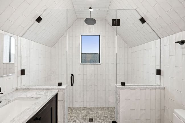 Bathroom featuring a stall shower, vanity, and lofted ceiling | Image 29