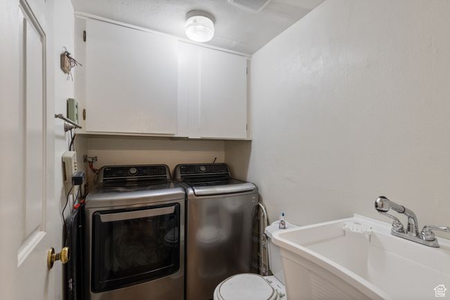 Laundry area featuring washing machine and dryer and cabinet space | Image 18