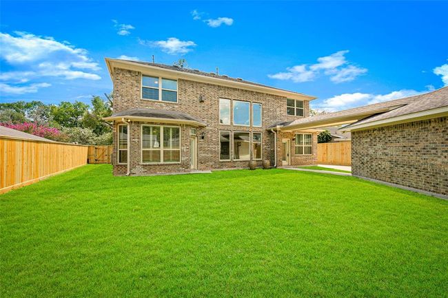 Spacious backyard with lush green lawn, perfect for entertaining, play, or relaxation. Fully fenced for privacy and framed by the home’s beautiful brick exterior. | Image 41
