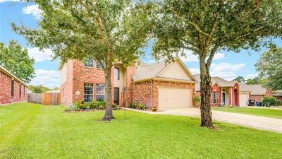 Charming two-story home near the heart of Magnolia is nestled on a cul-de-sac, surrounded by beautiful front flowers and mature oak trees. | Image 1