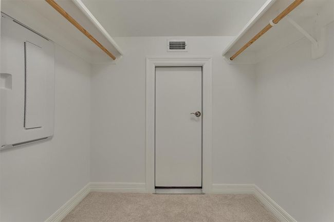 The second floor closet features multiple hanging rods and convenient door access to the attic. The attic is partially floored around the second floor area, providing easy and accessible storage. | Image 37