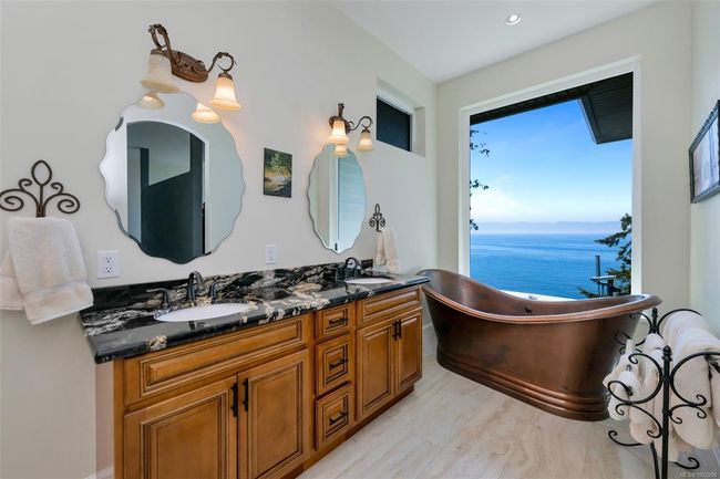 Bathroom featuring connected bathroom, double vanity, tiled shower, and a freestanding tub | Image 11