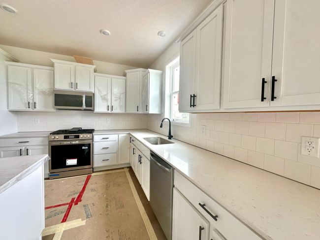 (Photo of an inventory home, actual homes finishes will vary) Soaked in natural sunlight, the homes eat-in dining room has ample space for a dining table. | Image 9