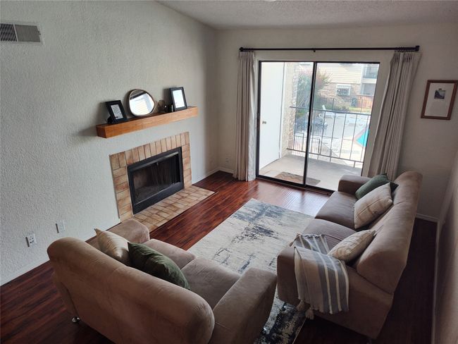 Living room featuring dark hardwood / wood-style flooring, and a fireplace | Image 4