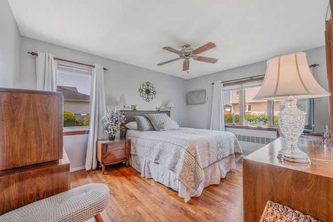 Bedroom featuring radiator, light wood-style flooring, and a ceiling fan | Image 15