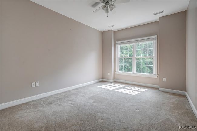 Spacious secondary bedrooms feature brand-new carpeting, ceiling fans, generous closets, and abundant natural light for a bright and comfortable retreat. | Image 38