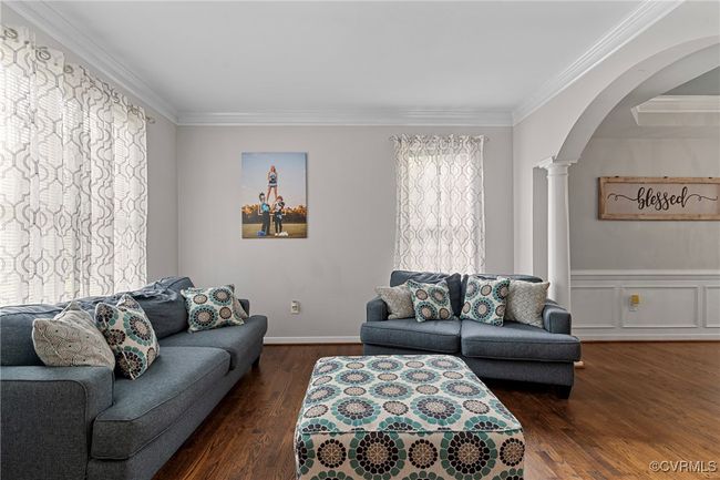 Living room with crown molding, arched walkways, decorative columns, and wood finished floors | Image 24