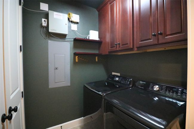 Laundry room with washing machine and dryer, baseboards, cabinet space, and electric panel | Image 27