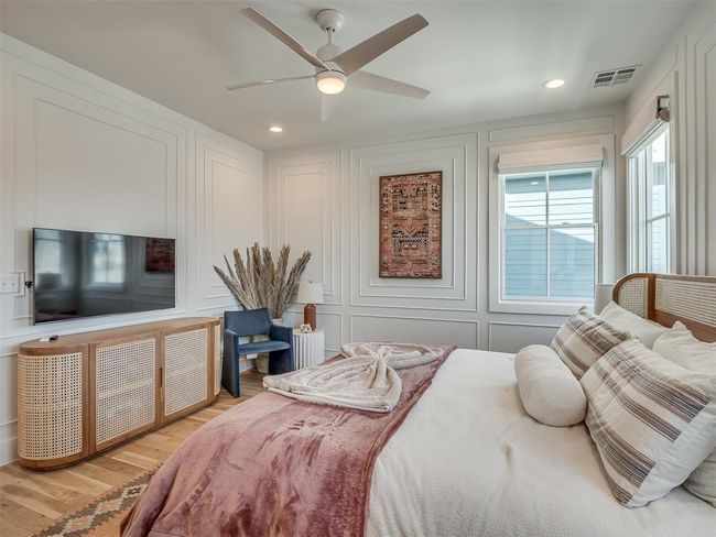 Bedroom with a decorative wall, wood finished floors, ceiling fan, and recessed lighting | Image 27