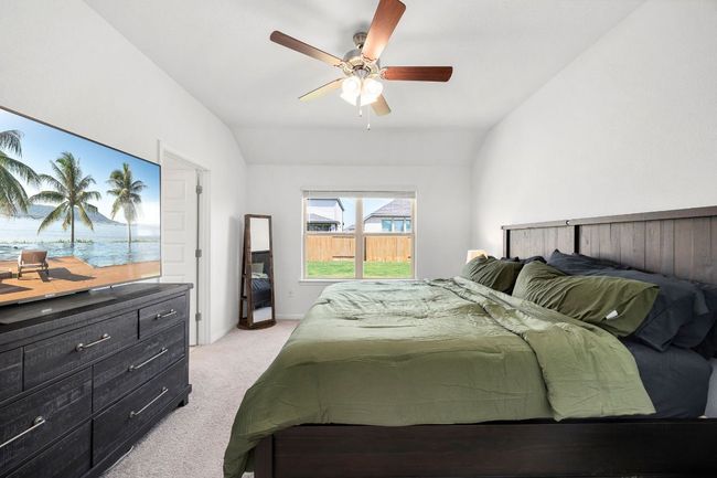 Bedroom with light carpet, vaulted ceiling, and a ceiling fan | Image 20