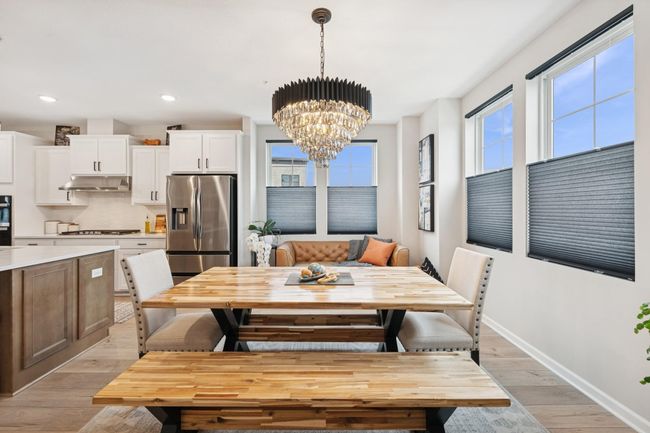Dining space off the kitchen filled with natural light from abundant windows, featuring a beautiful upgraded black and crystal chandelier for an elegant touch. | Image 24