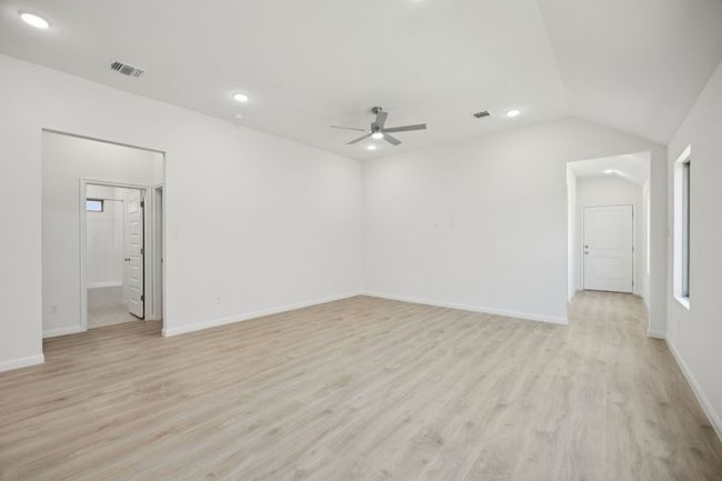 Empty room with a ceiling fan, light wood-style flooring, recessed lighting, and lofted ceiling | Image 17