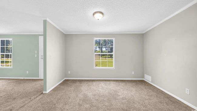Spare room featuring crown molding, carpet, and a textured ceiling | Image 10