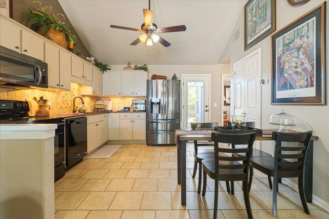 Kitchen featuring a ceiling fan, tasteful backsplash, vaulted ceiling, and black appliances | Image 9