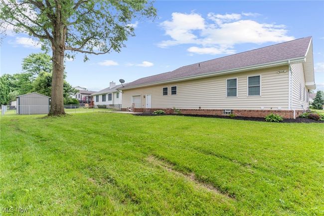 Back of house with a fenced backyard and crawl space | Image 43