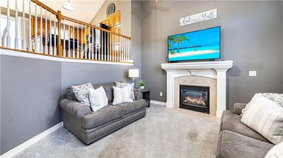 Living room with high vaulted ceiling, a tile fireplace, and carpet flooring | Image 3