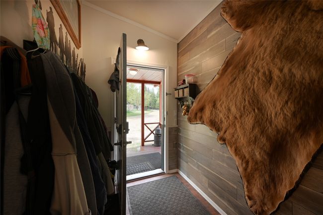 Doorway to outside with wooden walls, crown molding, and wood finished floors | Image 13