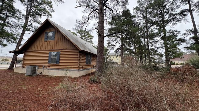 View of property exterior with board and batten siding, cooling unit, metal roof, and log siding | Image 30