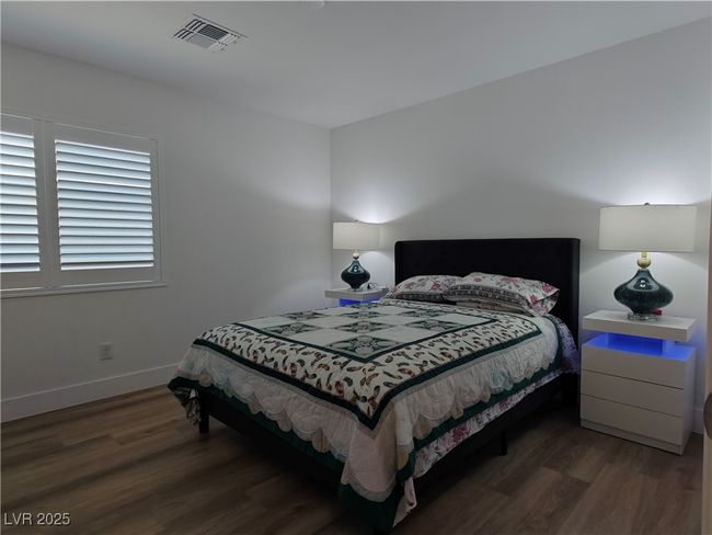 Bedroom with visible vents, wood finished floors, and baseboards | Image 30