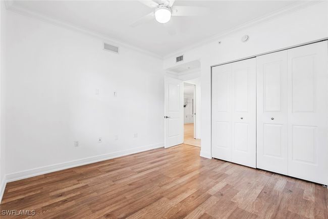 Unfurnished bedroom with ornamental molding, a closet, light wood-type flooring, and ceiling fan | Image 25