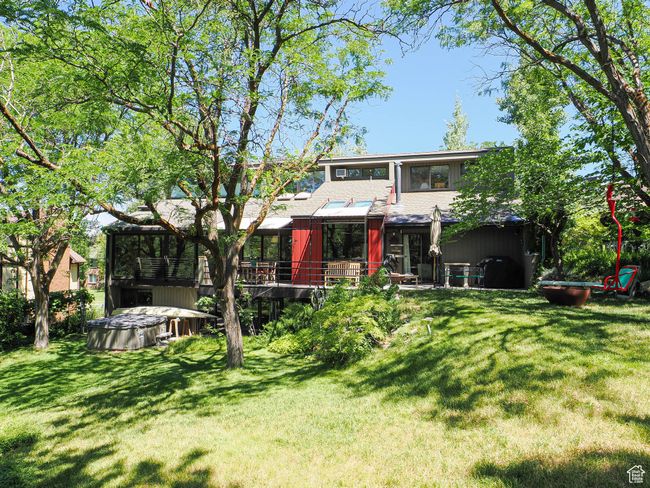 Rear view of house with a hot tub, a yard, and a deck | Image 63