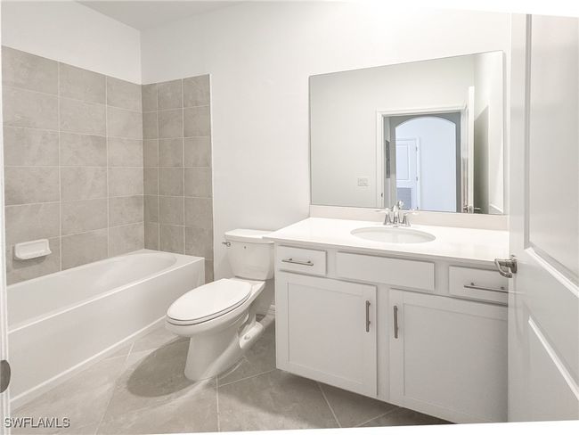 Bathroom with toilet, tile patterned floors, vanity, and shower combination | Image 18