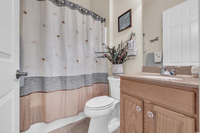 Full bath featuring toilet, vanity, curtained shower, and tile patterned floors | Image 9