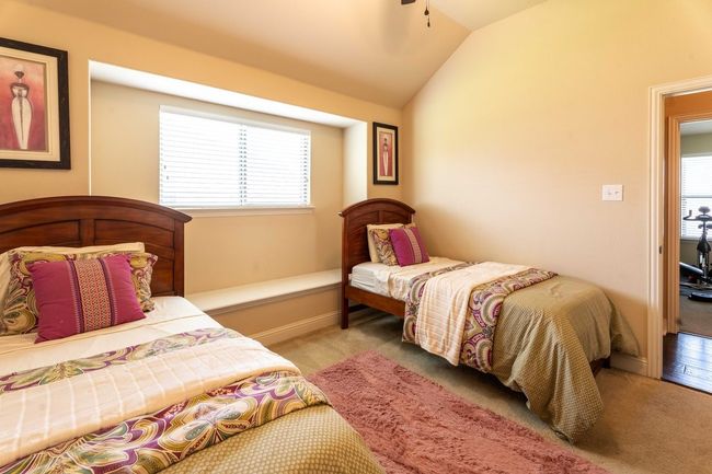 Bedroom featuring window, ceiling fan, light carpet, and decorative bench | Image 16