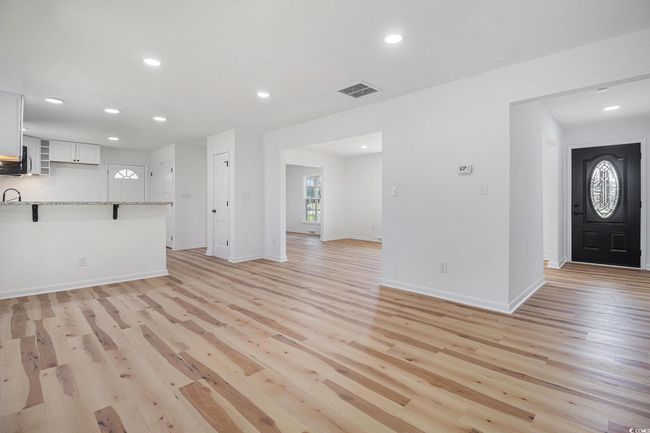 Family Room featuring an eat-in-kitchen bar and can also serve as a dining/family combo room. Features new luxury vinyl plank flooring. | Image 9