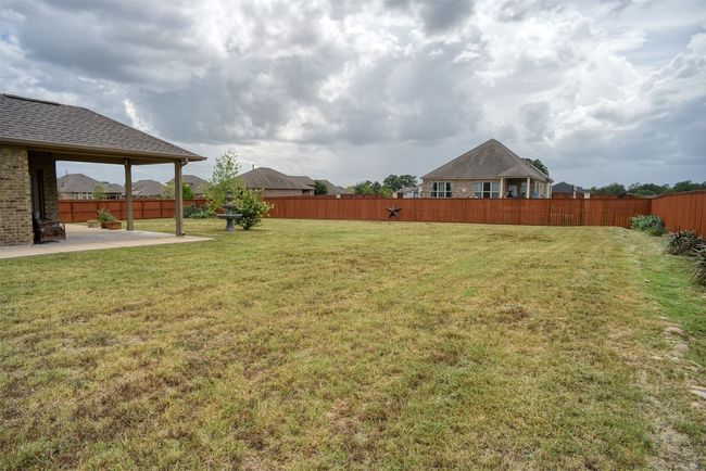 Fenced backyard with a patio | Image 30