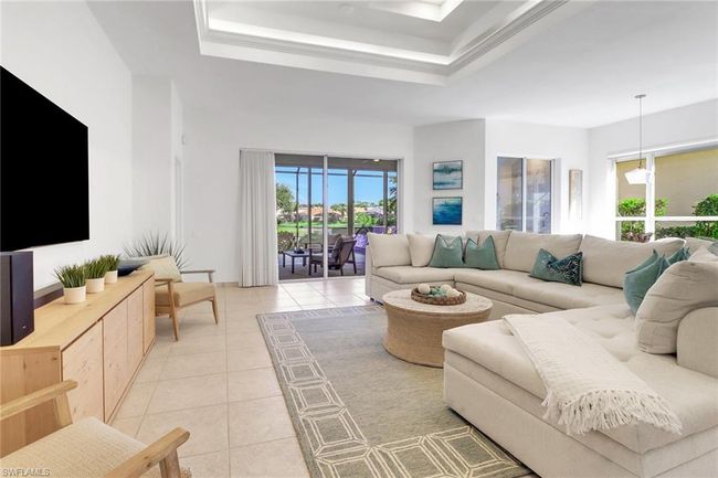 Living room with light tile patterned flooring and a tray ceiling | Image 7