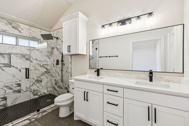Bathroom with a marble finish shower, double vanity, and vaulted ceiling | Image 17