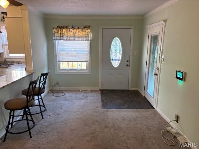 Entryway with carpet floors, ornamental molding, a textured ceiling, and baseboards | Image 16