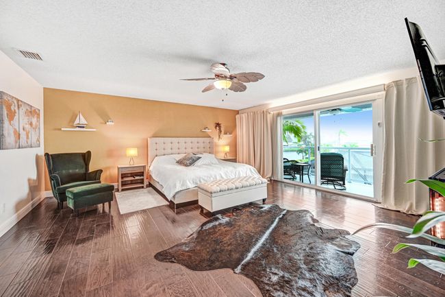 Expansive, private second floor master suite, with Oversized sliders leading to its own deck, overlooking the pool, canal, nature preserve, and SpaceX rocket launches. | Image 8