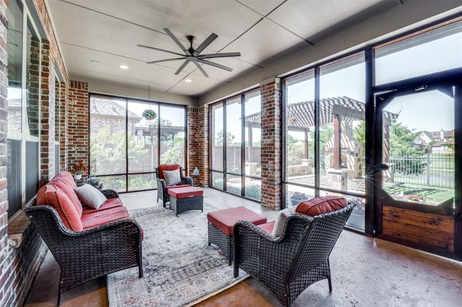 The perfect outdoor living space—screened-in for comfort—features a large ceiling fan and serene water views, creating a relaxing retreat for any time of day. | Image 32