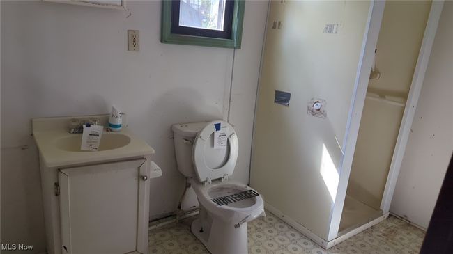 Full bath featuring vanity, tile patterned floors, a stall shower, and toilet | Image 5
