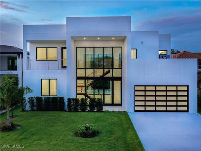 Modern home featuring a garage, a balcony, and a lawn | Image 1