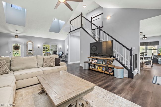 Living room featuring high vaulted ceiling, a healthy amount of sunlight, dark wood-type flooring, and ceiling fan | Image 9