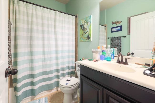 Full bath featuring toilet, vanity, tile patterned floors, and a shower with shower curtain | Image 19