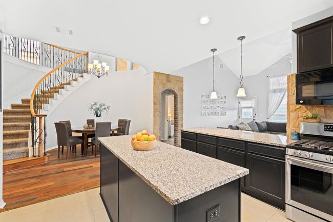 Kitchen with gas stove, black microwave, high vaulted ceiling, a kitchen island, and light tile patterned floors | Image 8