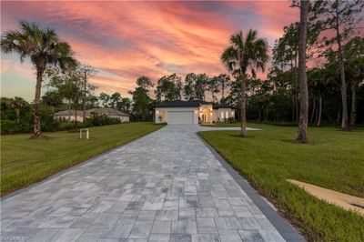 Ranch-style home with a garage and a lawn | Image 1