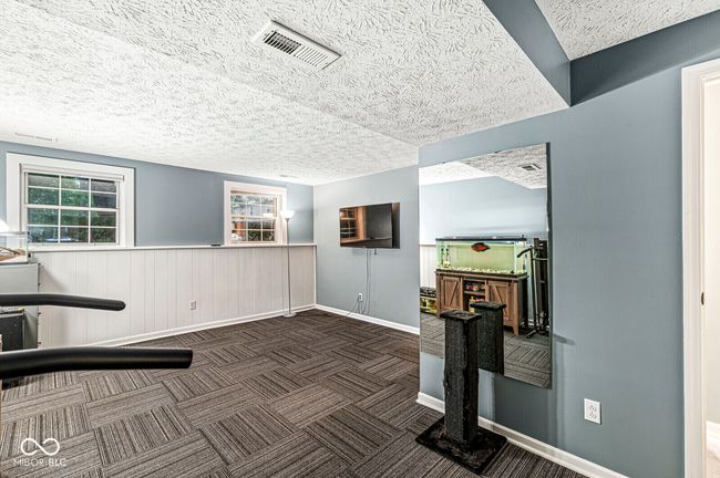 workout area with a textured ceiling and carpet floors | Image 19