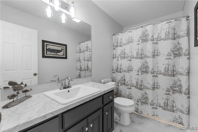 Bathroom featuring marble finish floor, curtained shower, vanity, and toilet | Image 26