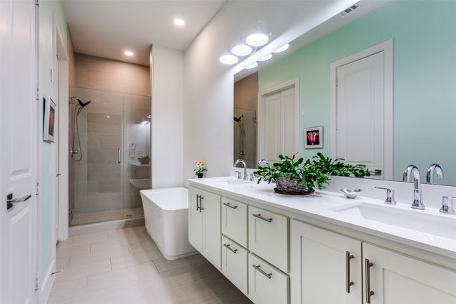Beautifully appointed bath featuring double vanity, a walk-in shower, quartz countertops and garden tub. The huge walk-in closet is on the left. | Image 17