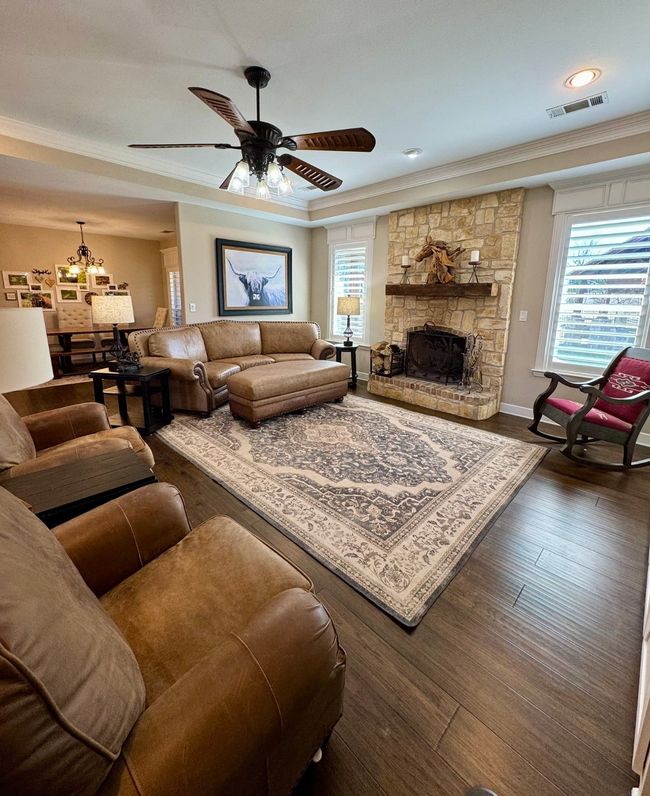 Living room with wood finished floors, visible vents, ornamental molding, and a wealth of natural light | Image 8