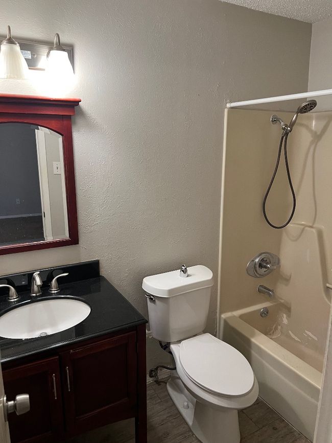 Bathroom featuring vanity, shower / bathtub combination, toilet, and wood finished floors | Image 16